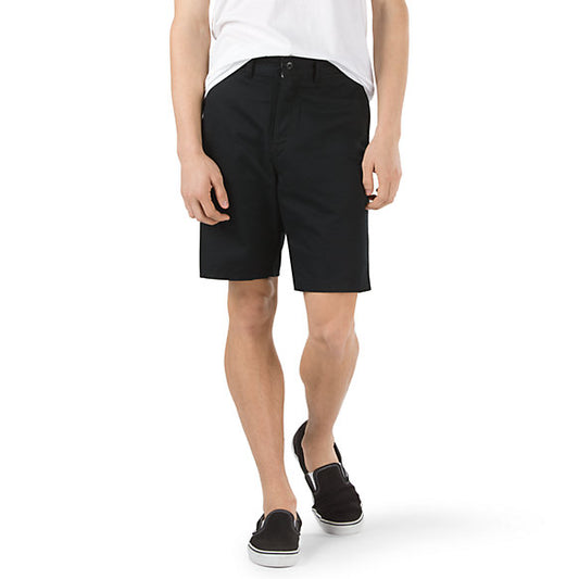 Vans Authentic Stretch Shorts front view. Black Shorts on model with white shirt. 